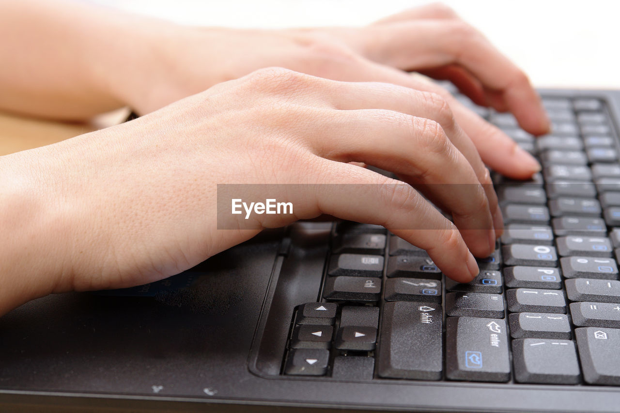 Cropped hands of person using laptop