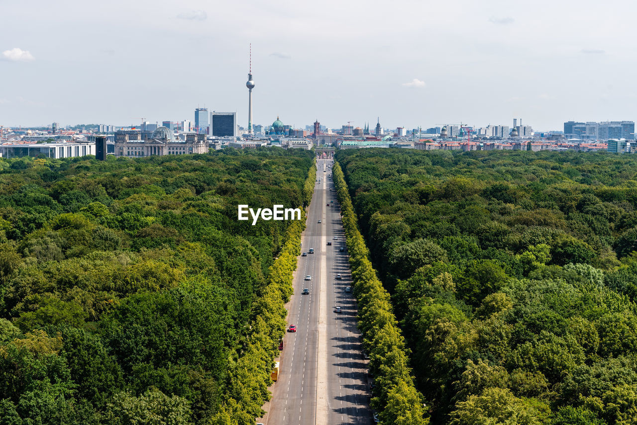 View of road passing through forest against sky