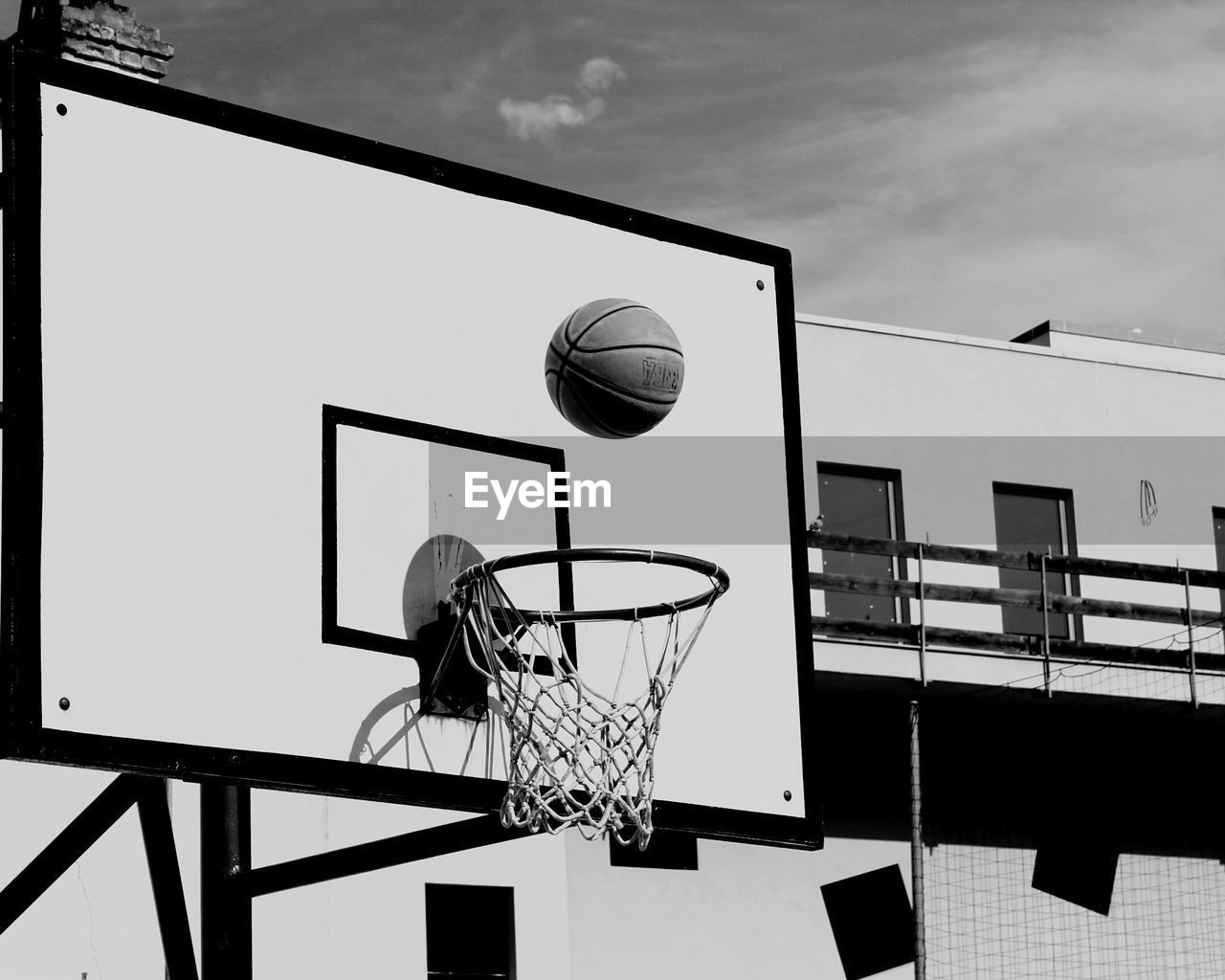 Basket ball over hoop on sunny day