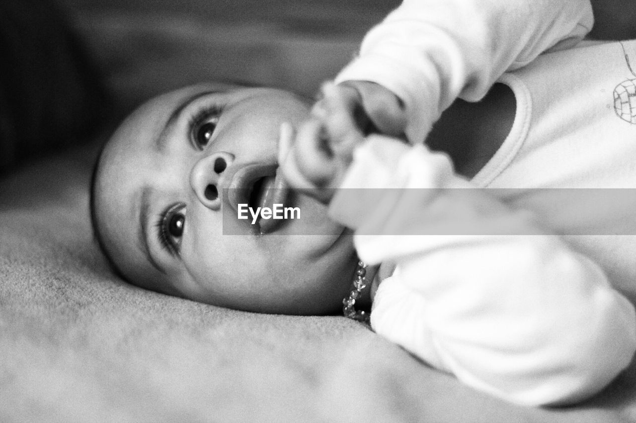 CLOSE-UP OF CUTE BABY GIRL ON BED