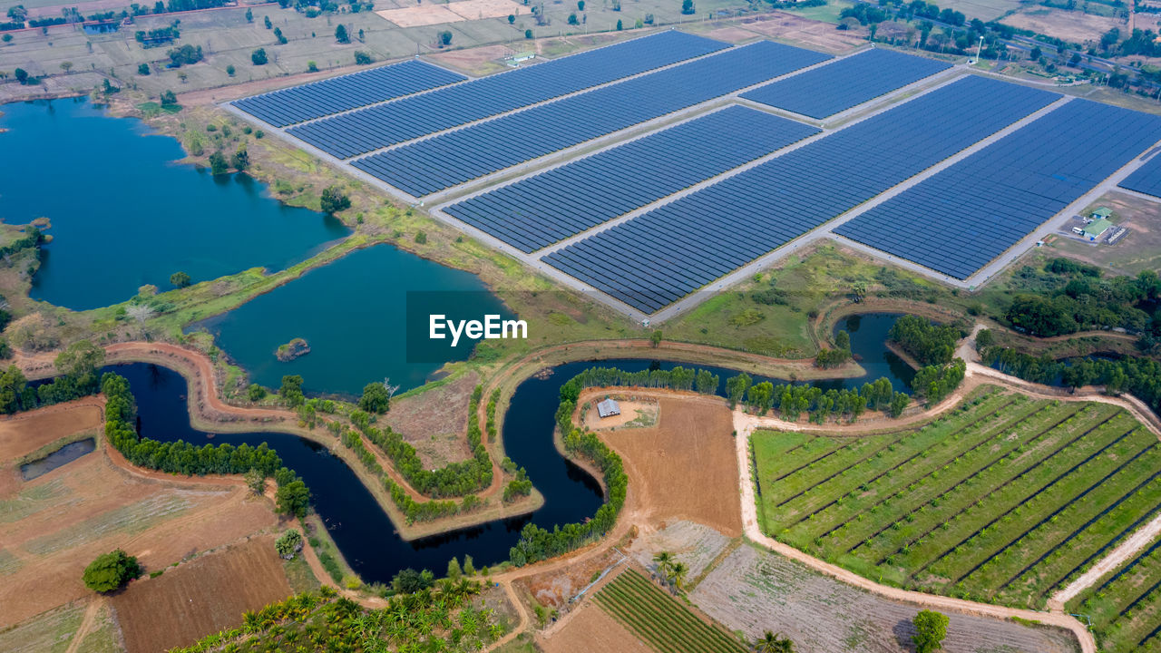 Solar panels farm between agriculture fields in aerial view. in thailand