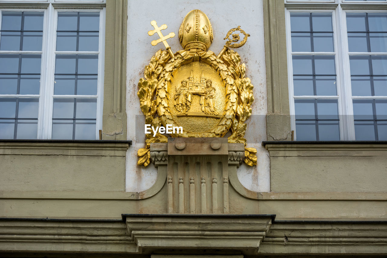 Golden coat of arms carving on roman catholic archdiocese of cologne