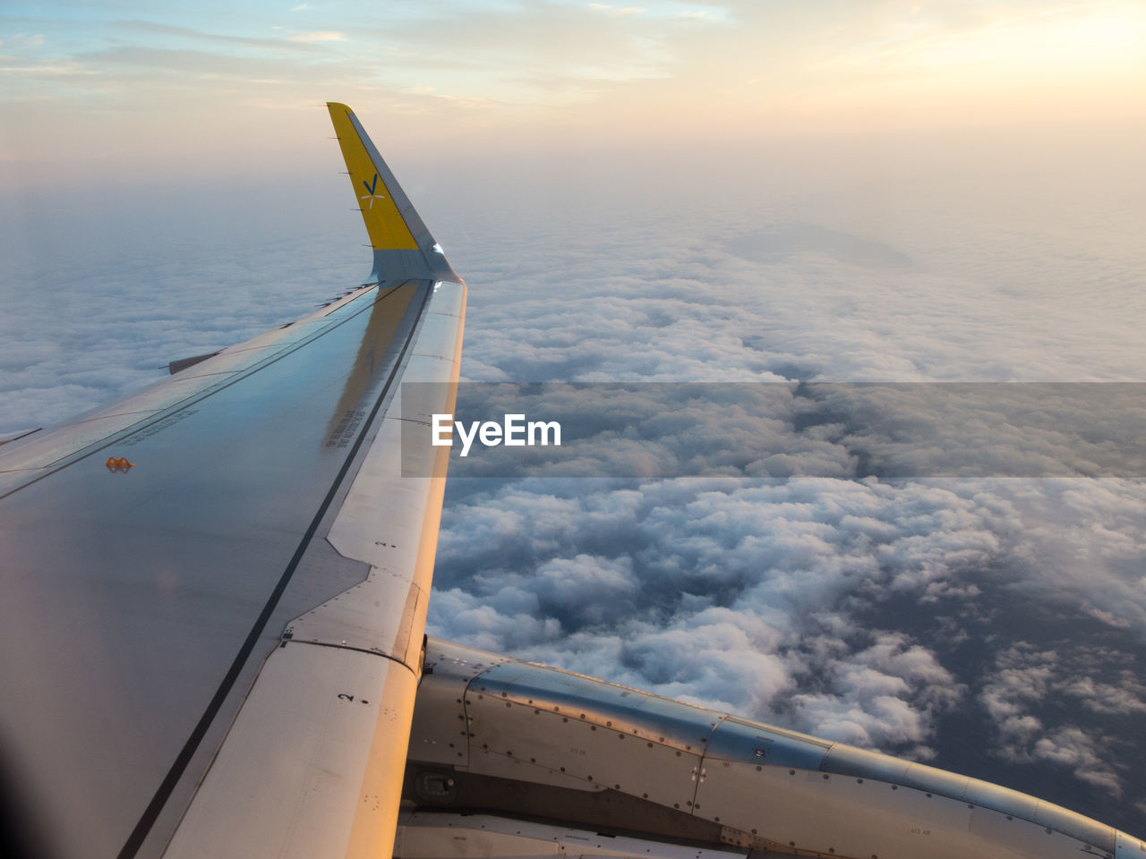 Cropped image of aircraft wing against sky during sunset