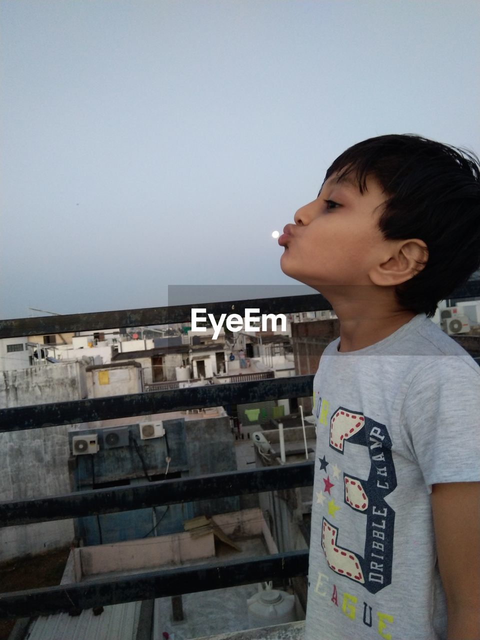 FULL LENGTH OF BOY LOOKING AT CAMERA AGAINST CLEAR SKY
