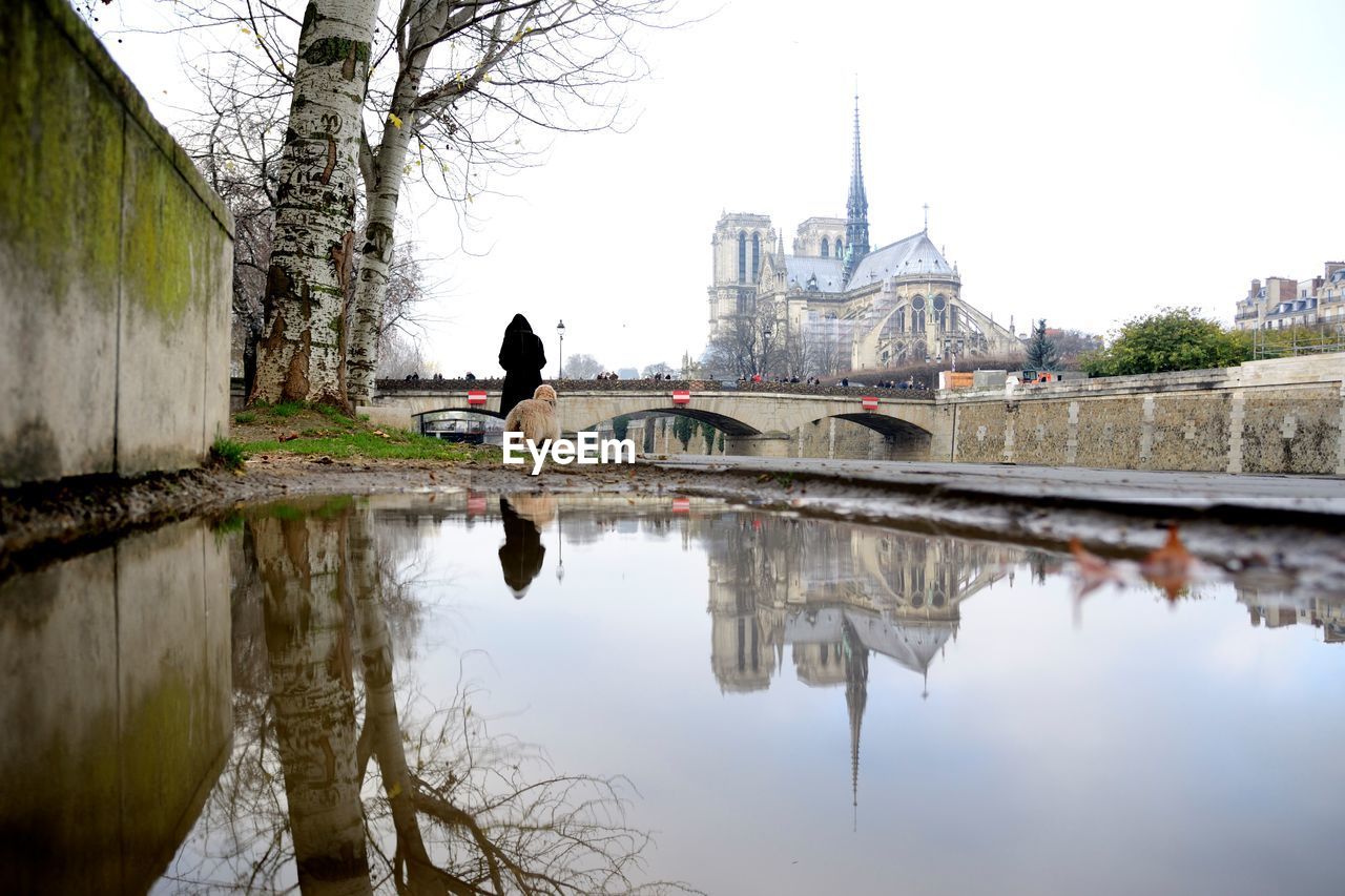 Reflection of arch bridge and building on river