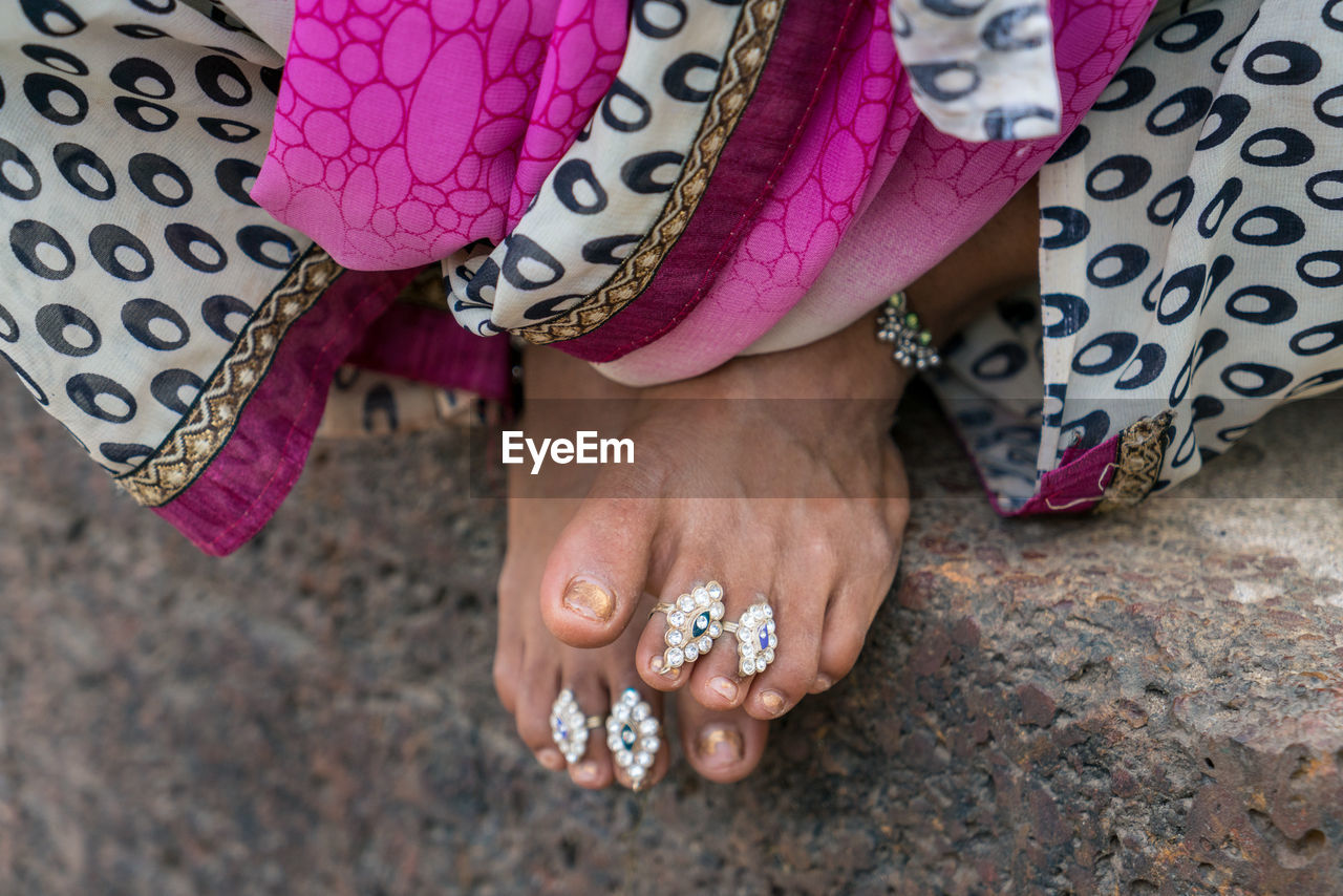 Low section of woman wearing rings