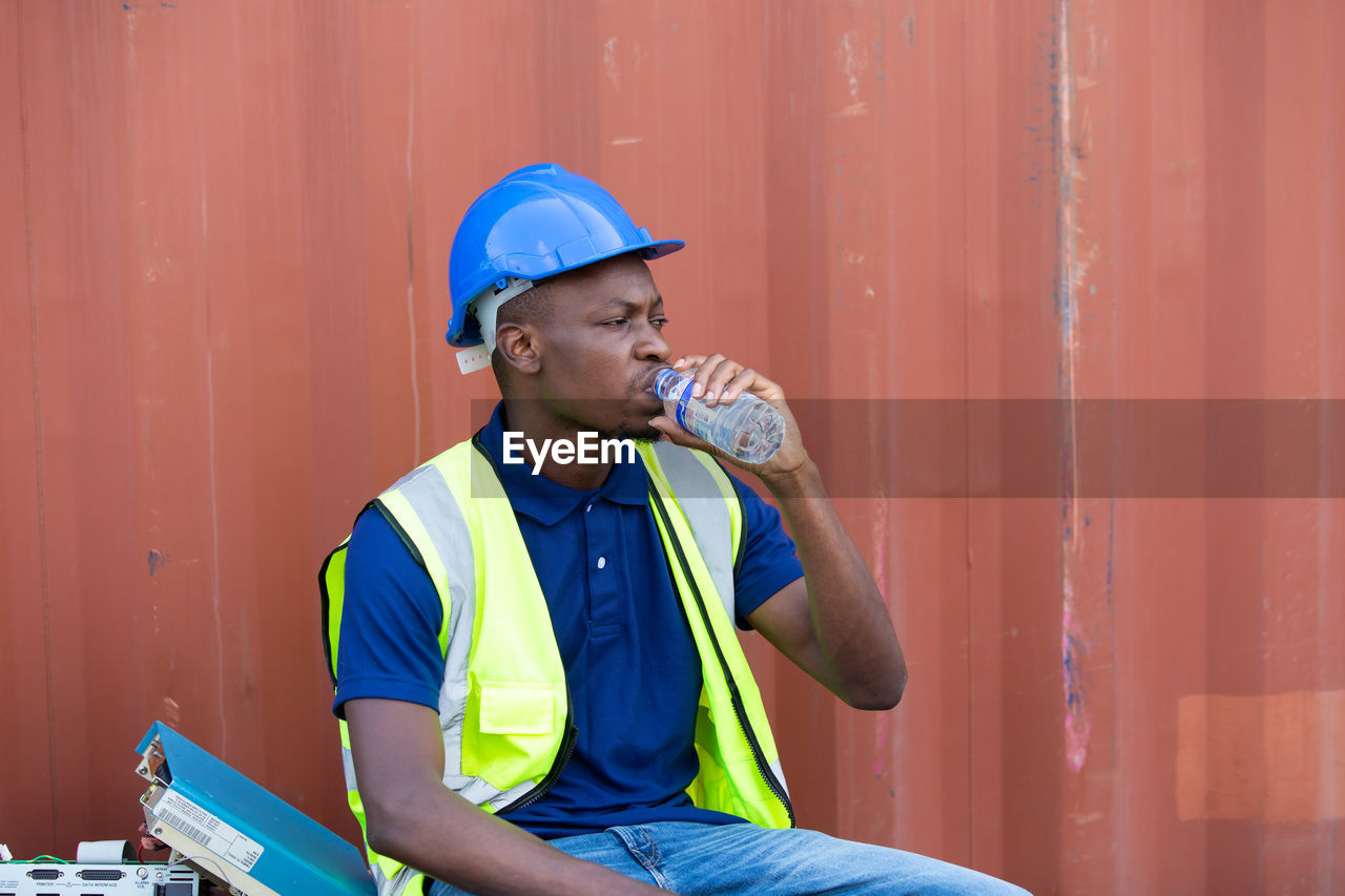 YOUNG MAN LOOKING AWAY WHILE SITTING