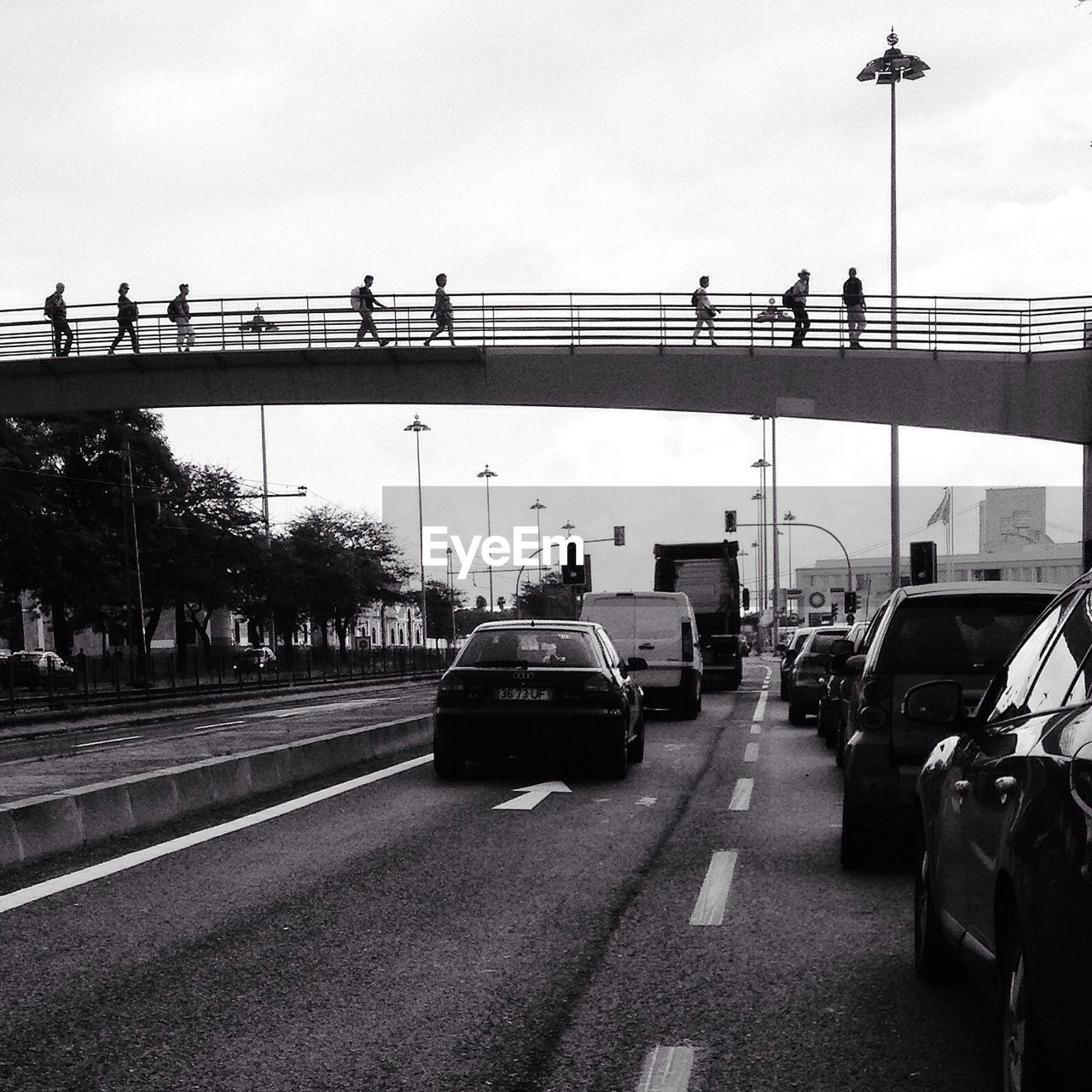 People walking on bridge over city street