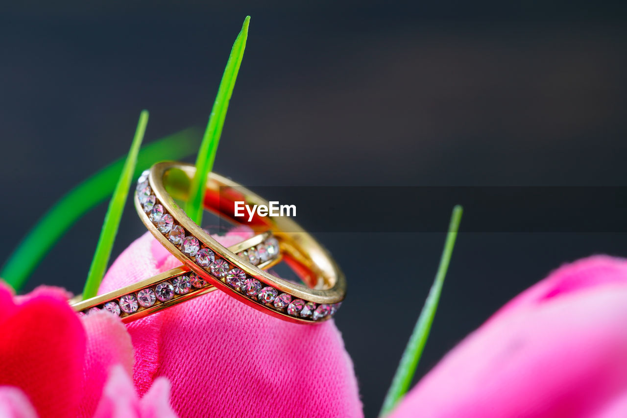 Diamond wedding ring resting in a fake pink tulip close up