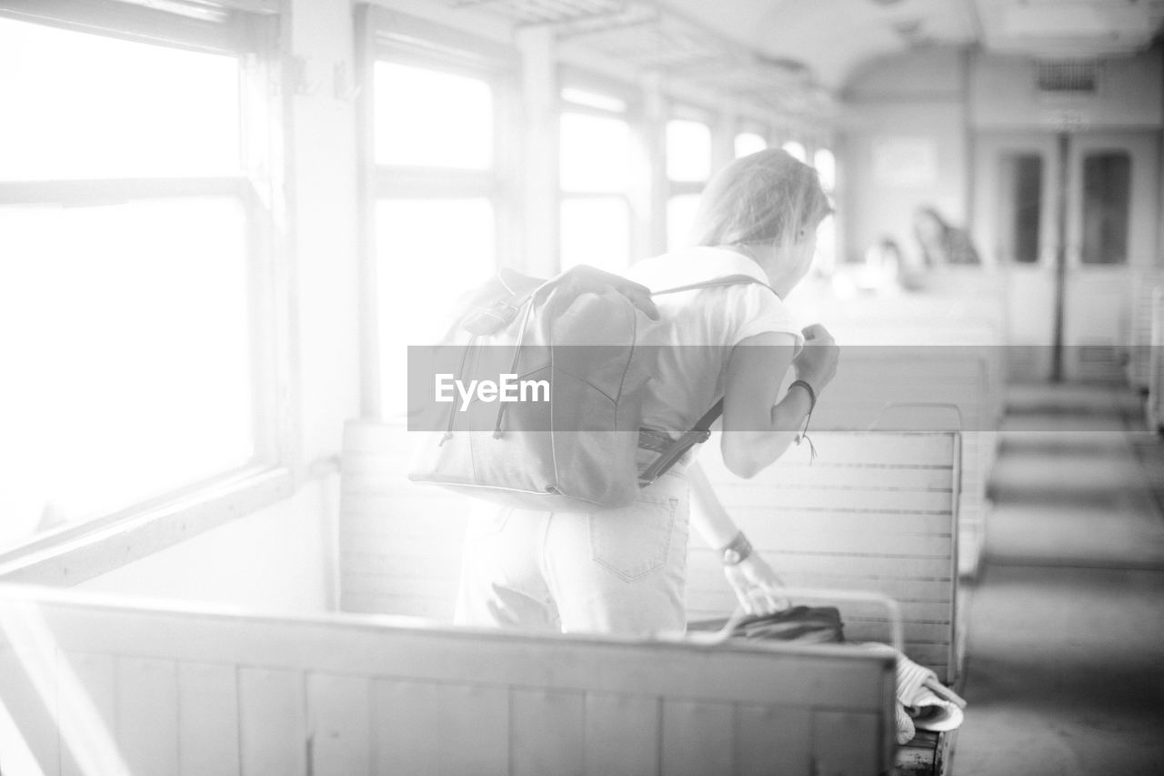 Woman with backpack standing in bus