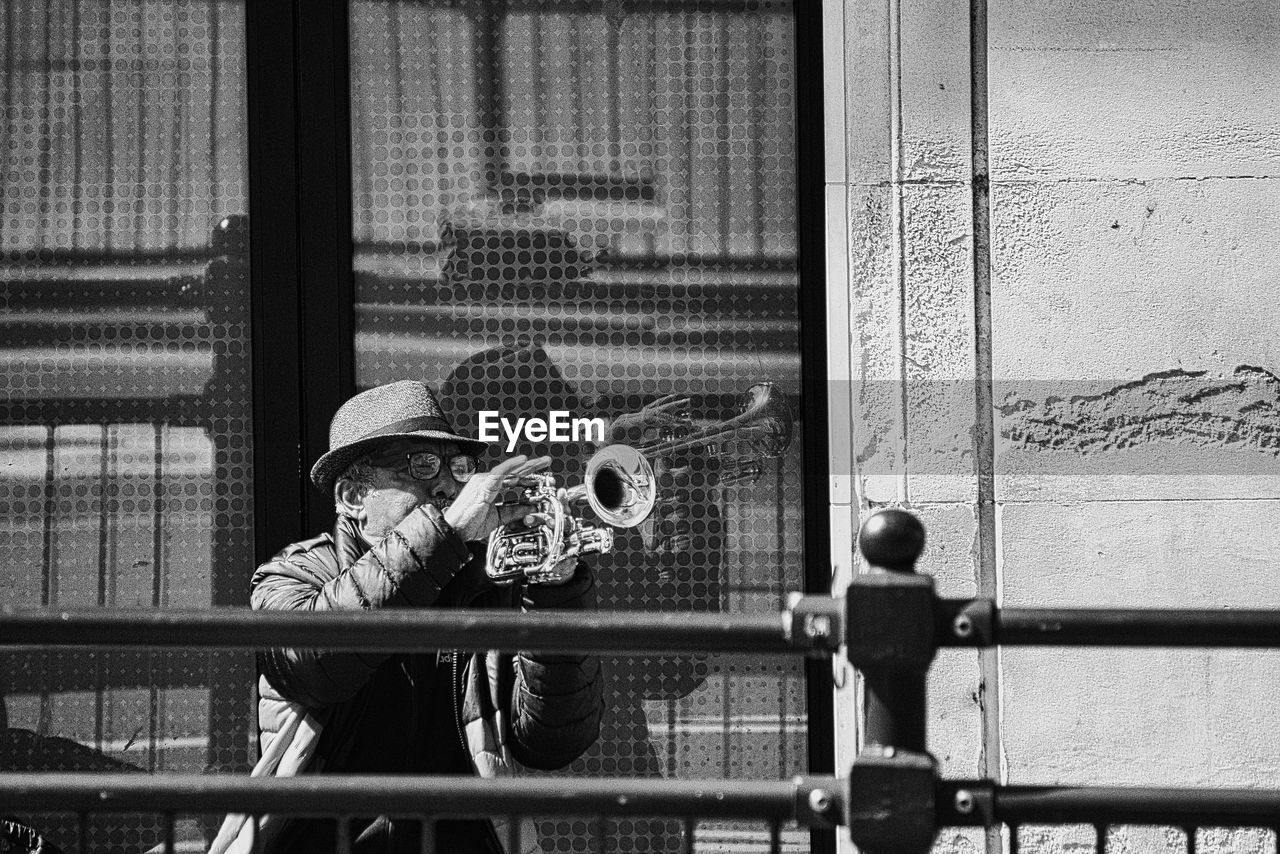 black, black and white, monochrome, monochrome photography, street, white, road, men, architecture, person, adult, built structure, day, hat, clothing, camera, leisure activity, lifestyles, building exterior, city, outdoors, casual clothing, one person