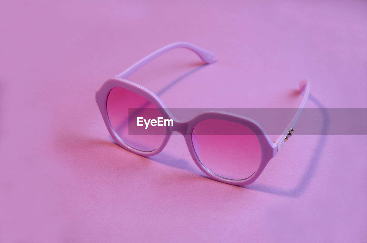 Close-up of sunglasses against pink background