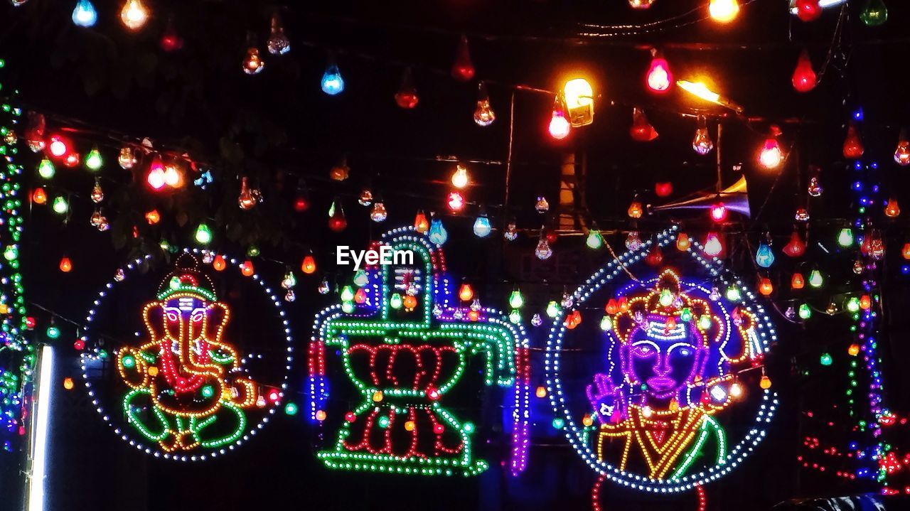 LOW ANGLE VIEW OF ILLUMINATED LIGHTS IN DARK