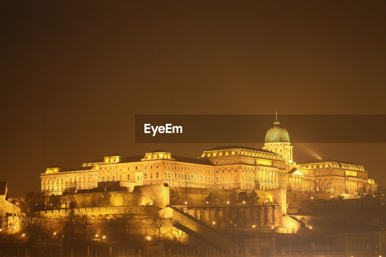 ILLUMINATED BUILDINGS IN CITY AGAINST SKY AT NIGHT