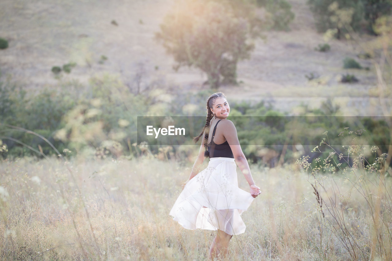 Portrait of smiling woman dancing on land