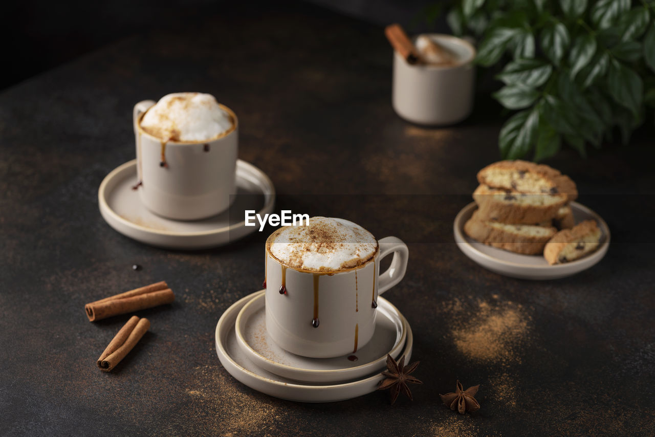 CLOSE-UP OF COFFEE CUP AND COOKIES