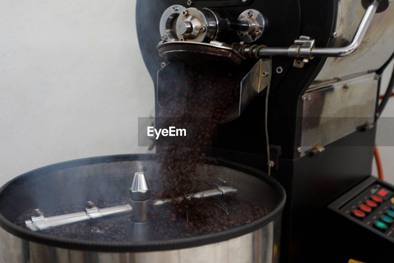 Coffee beans roasting in spin machine amd smoke at community industries doi chang chiang rai