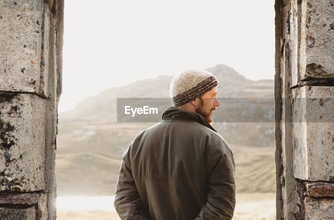 Rear view of man looking standing against mountains