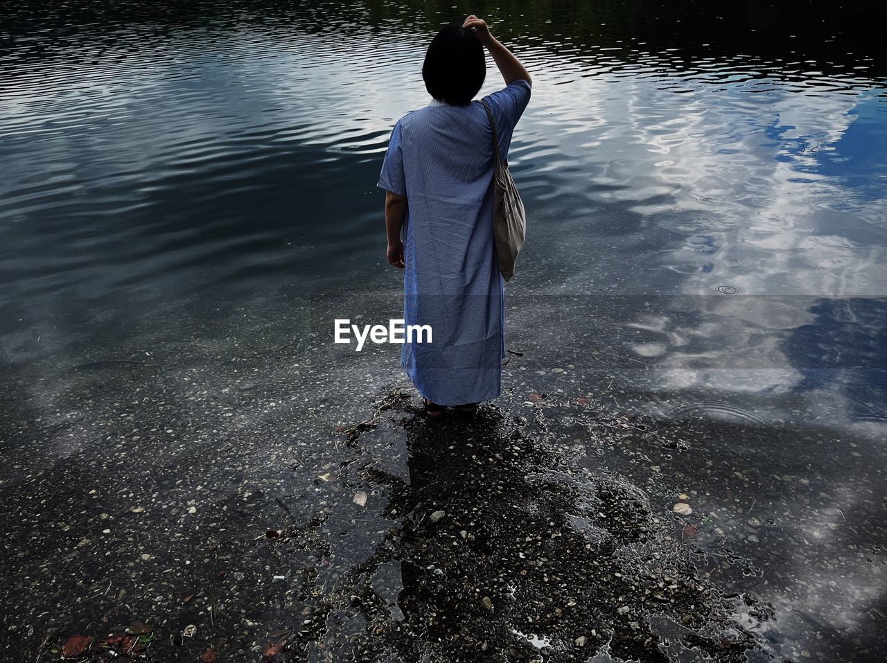 water, reflection, one person, rear view, nature, blue, sunlight, sea, adult, full length, outdoors, day, lifestyles, wet, leisure activity, rippled, standing, casual clothing, wave, men, solitude, darkness