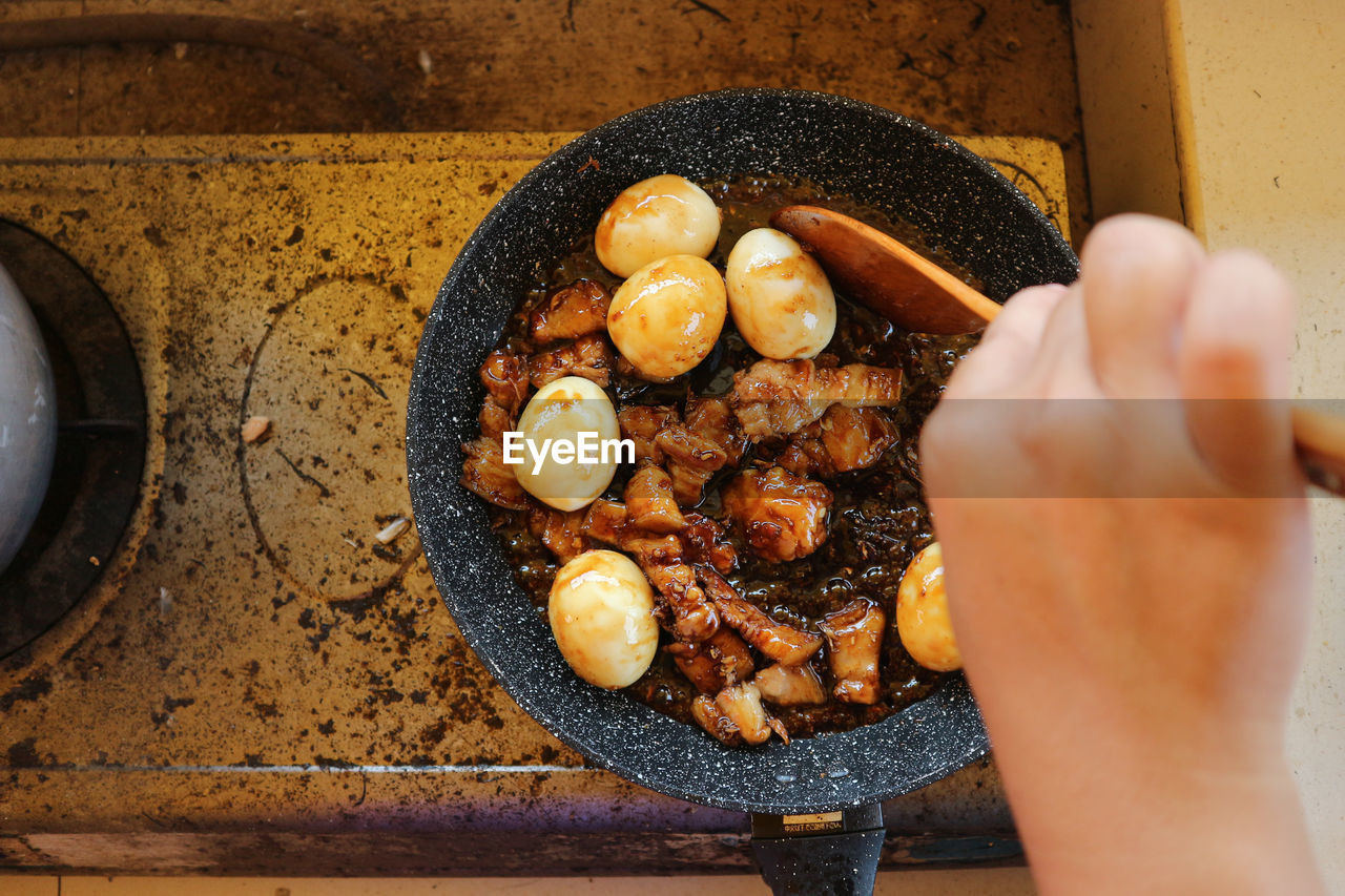 HIGH ANGLE VIEW OF PERSON PREPARING BREAD IN CONTAINER