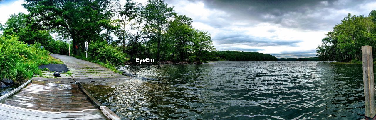 Scenic view of river amidst trees against sky