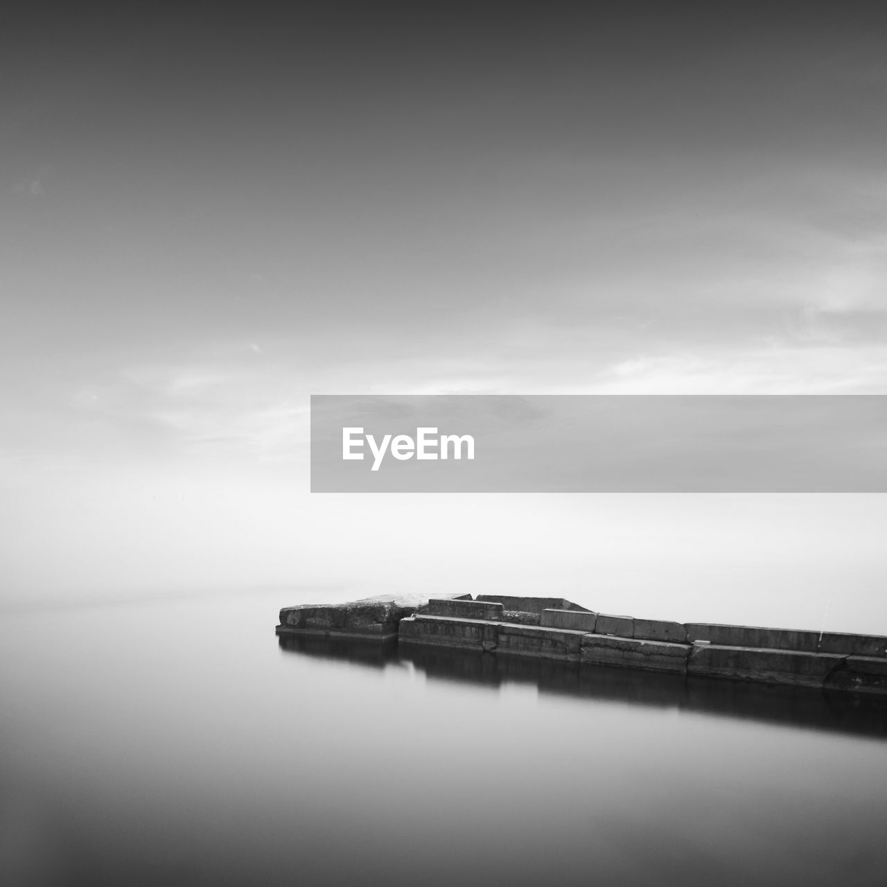 Pier amidst sea against cloudy sky