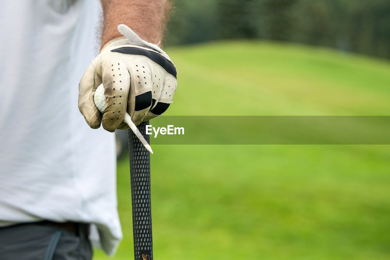 Close-up of hand holding golf course