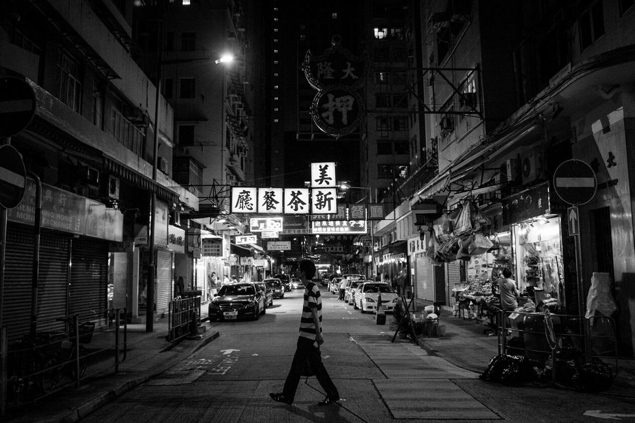 Side view of man crossing illuminated street