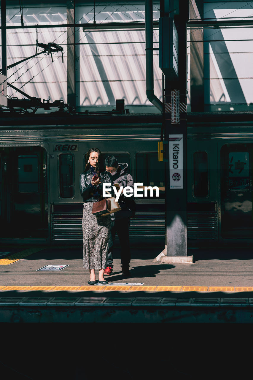 PEOPLE WAITING AT RAILROAD STATION