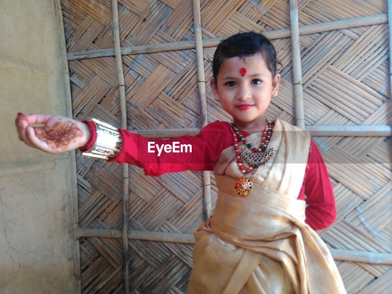 Portrait of girl wearing traditional clothing against wall