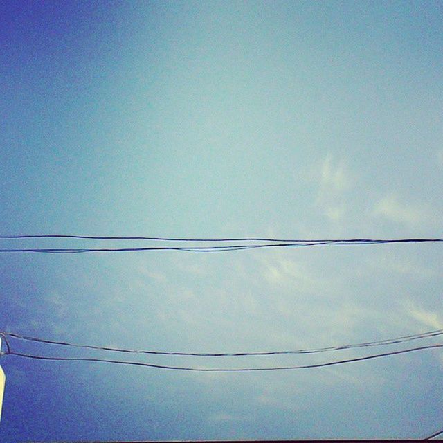 LOW ANGLE VIEW OF POWER LINES AGAINST BLUE SKY AND CLOUDS