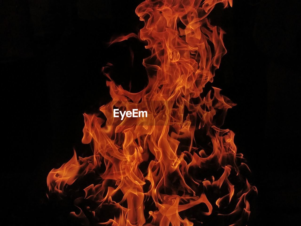 CLOSE-UP OF FIRE BURNING AGAINST BLACK BACKGROUND