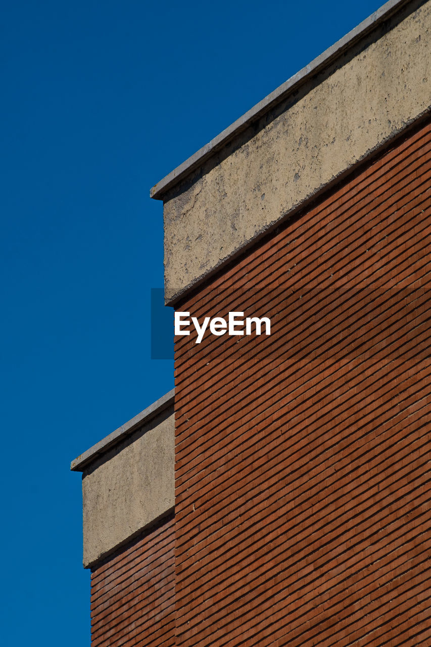 Low angle view of building against clear blue sky