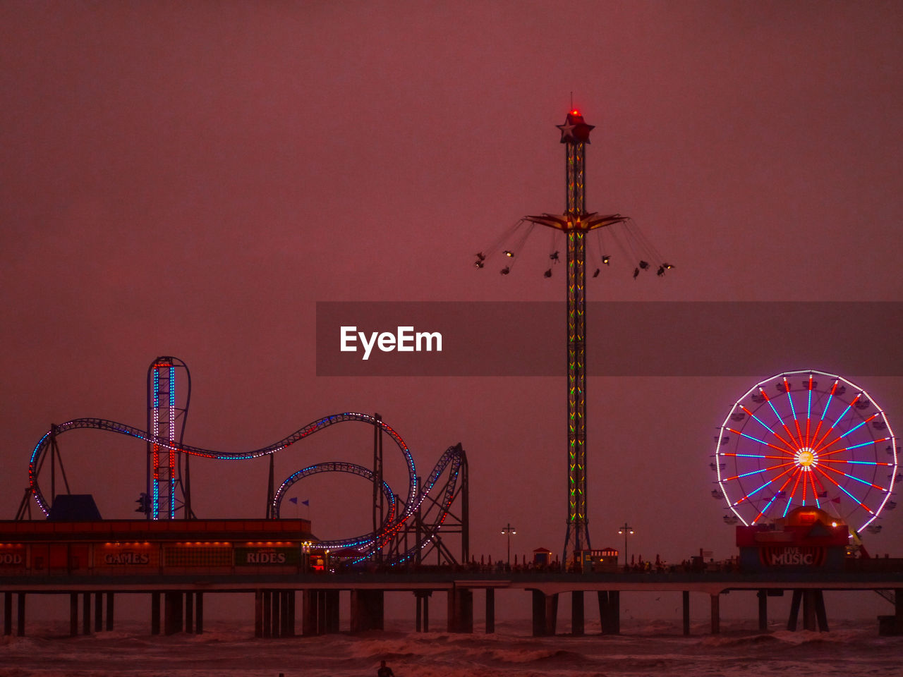 LOW ANGLE VIEW OF ILLUMINATED FERRIS WHEEL AGAINST SKY