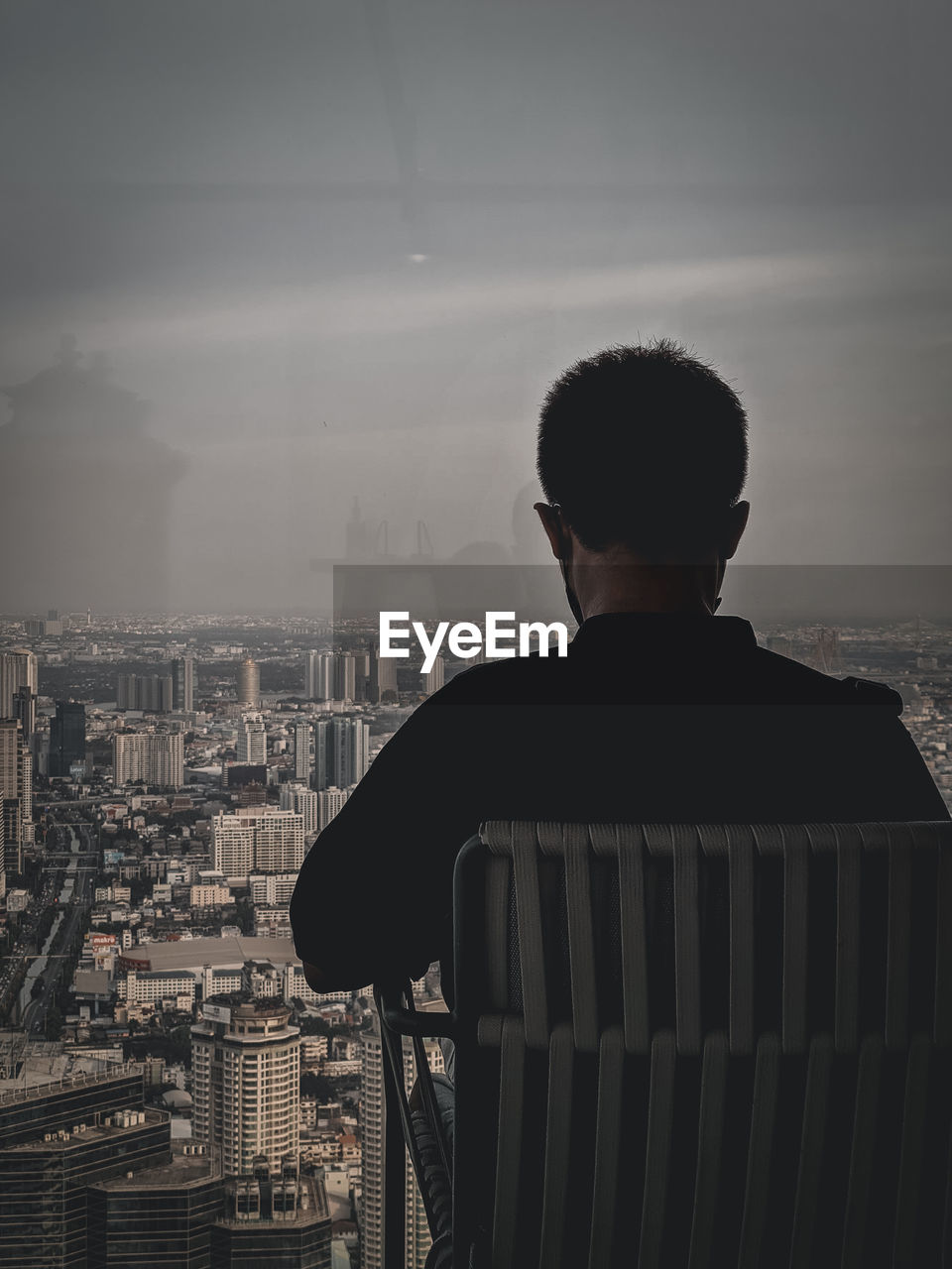 architecture, building exterior, cityscape, city, built structure, rear view, one person, black, sky, building, white, cloud, skyscraper, darkness, adult, office building exterior, urban skyline, men, morning, fog, looking at view, light, nature, looking, city life, silhouette, person, waist up, monochrome, skyline, black and white, landscape, standing, outdoors, sitting, business, residential district