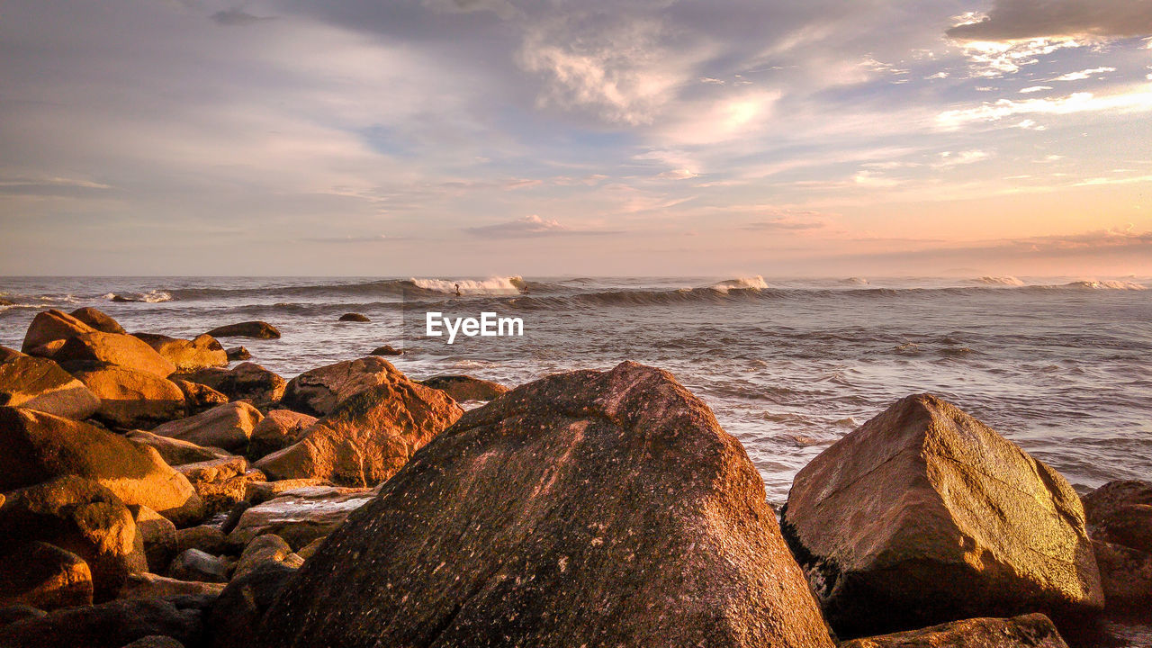 SCENIC VIEW OF BEACH AGAINST SKY DURING SUNSET