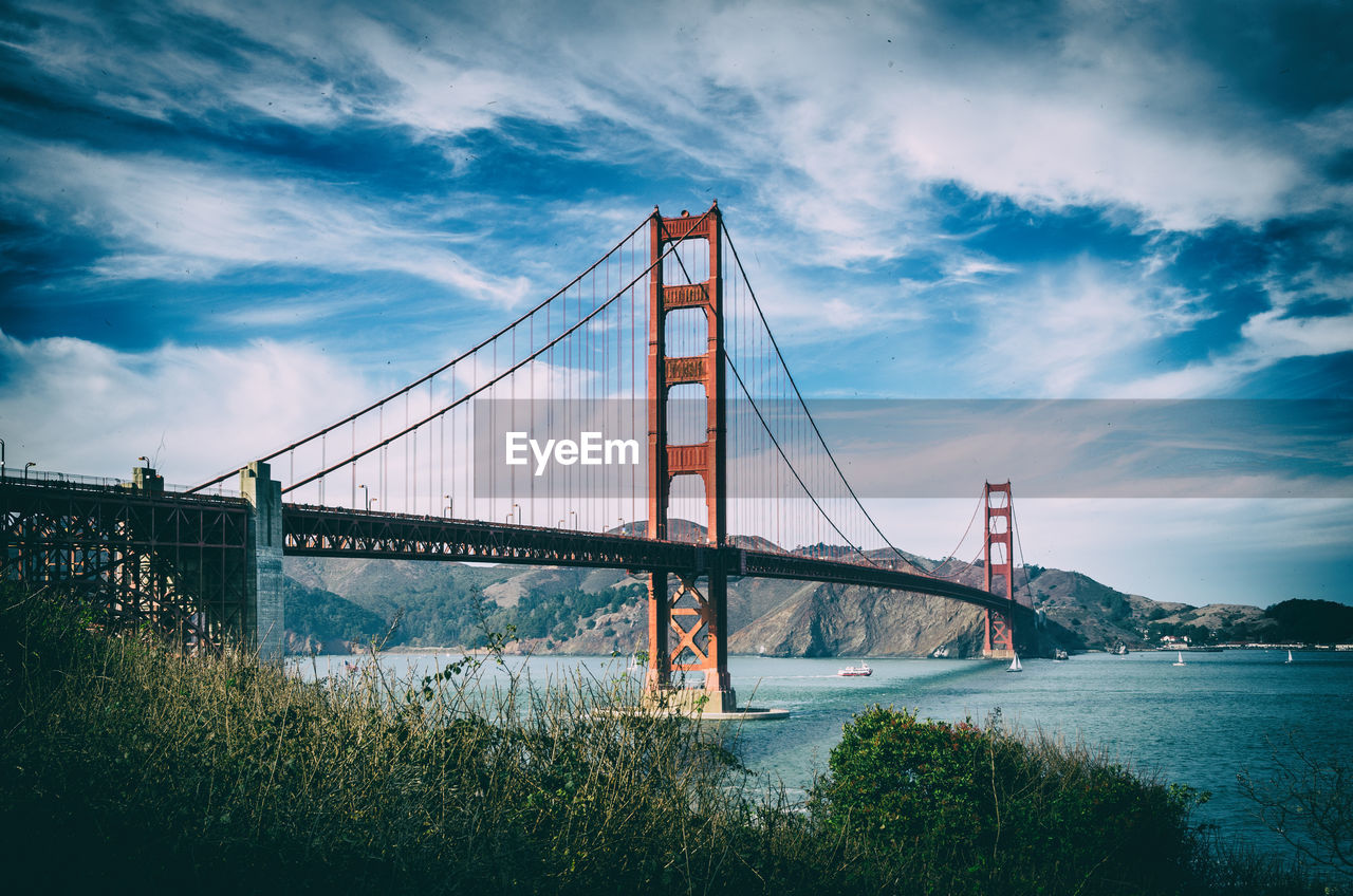 View of suspension bridge against cloudy sky