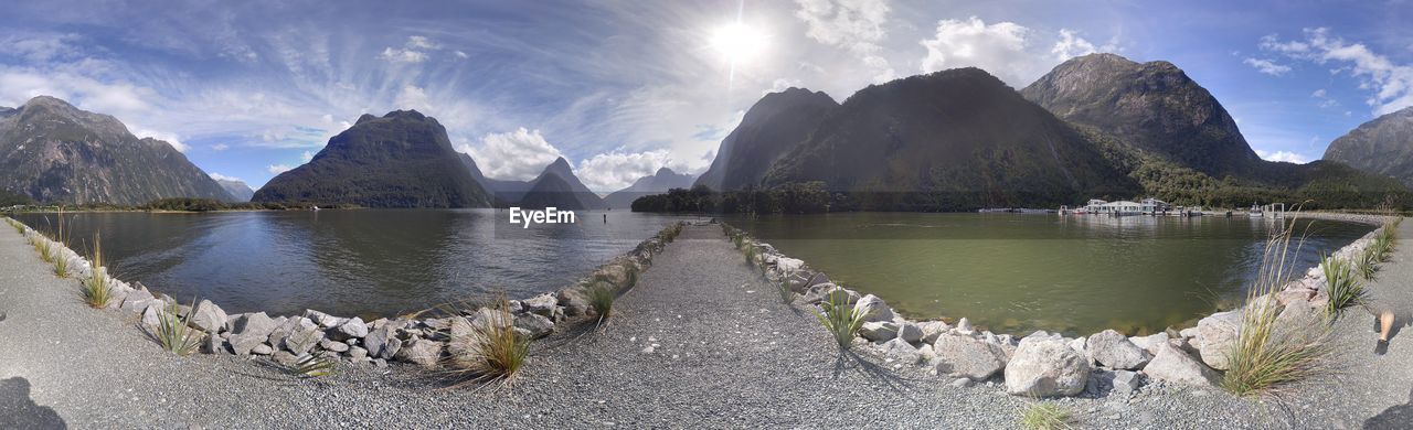 PANORAMIC SHOT OF CALM SEA AGAINST MOUNTAINS