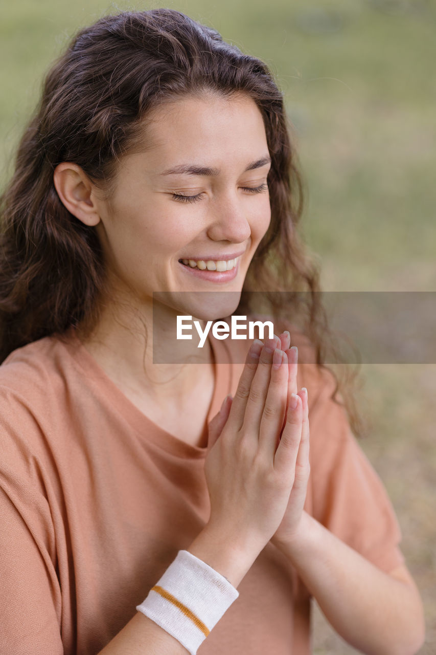 Woman with curly hair meditates in a park. yoga and meditation for mental and physical health