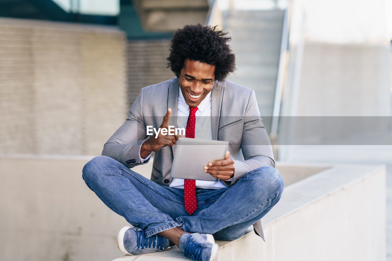 Smiling businessman using digital tablet outdoors