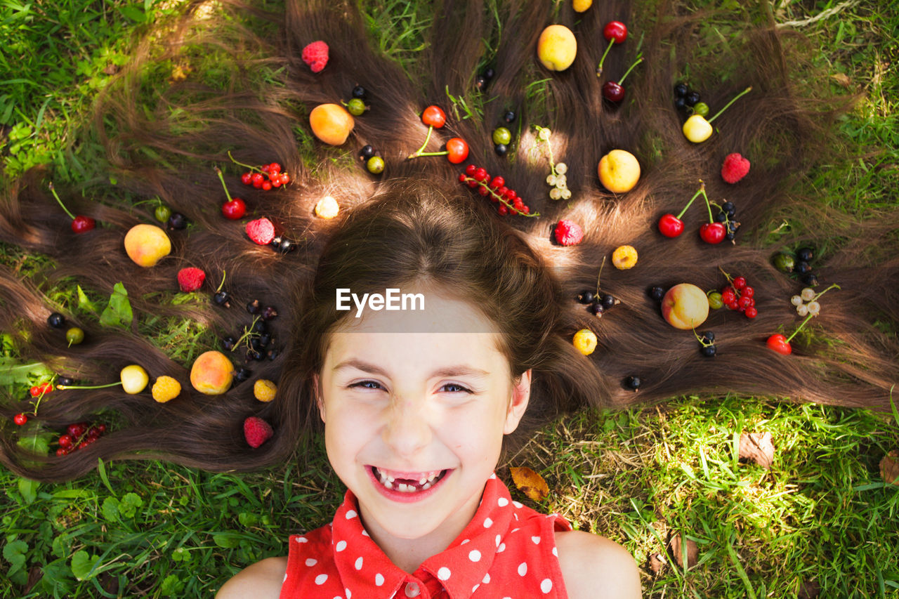 PORTRAIT OF A SMILING GIRL LYING ON THE GROUND