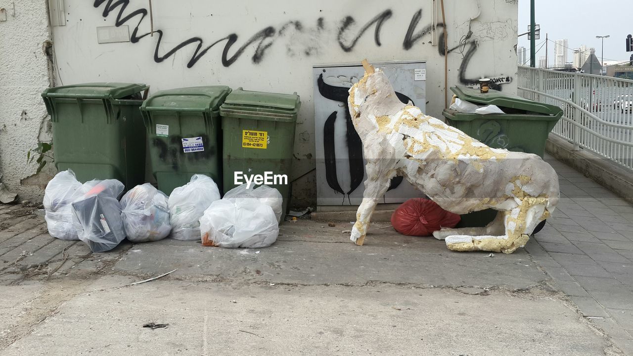 CLOSE-UP OF GARBAGE CAN ON WALL