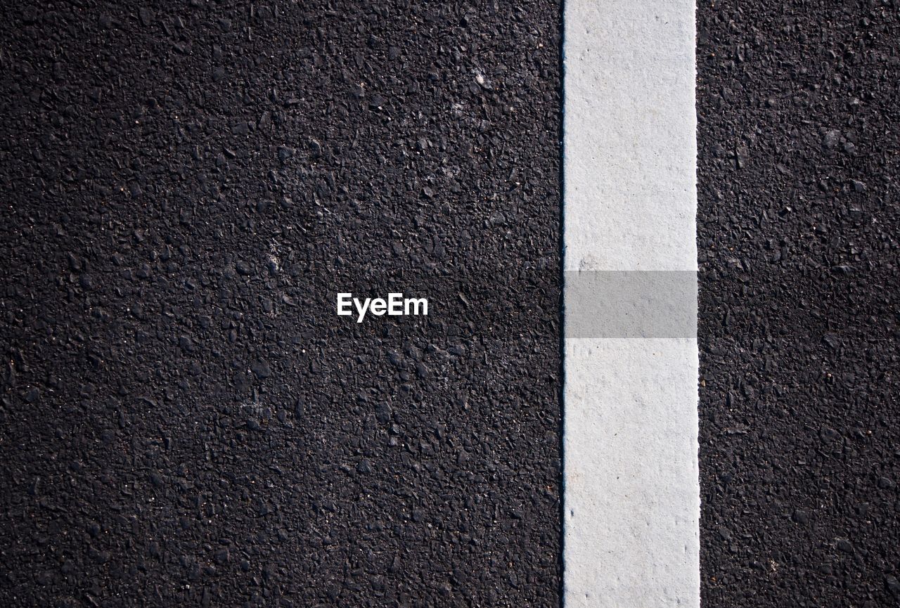 HIGH ANGLE VIEW OF ROAD MARKING ON CONCRETE