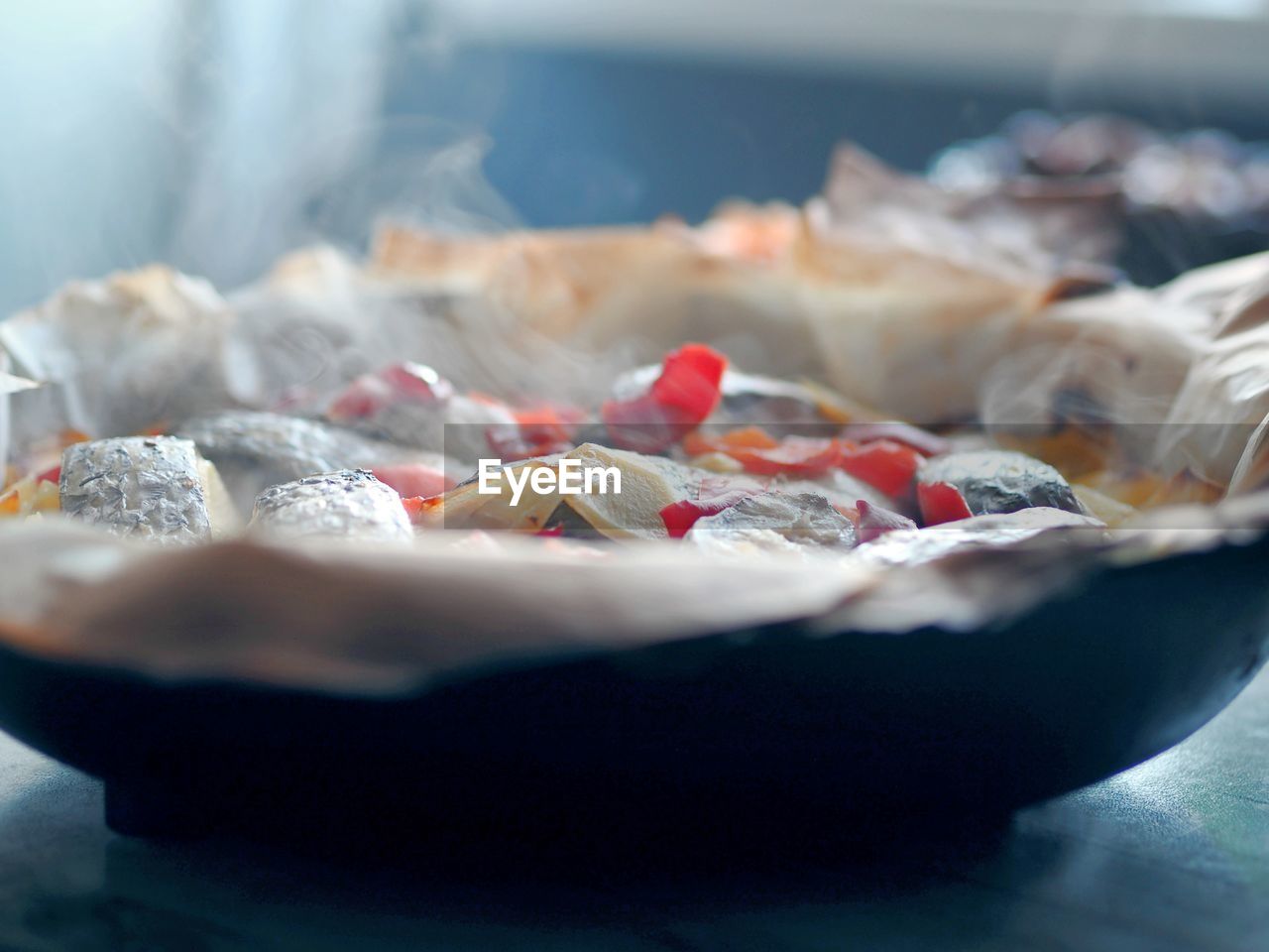 A frying pan just removed from the oven with baked potatoes with vegetables and chum 