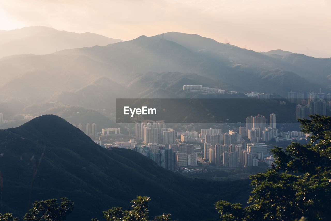 Buildings amidst mountains during foggy weather