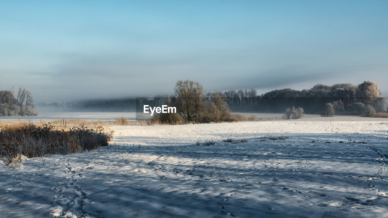 SNOW COVERED LAND AGAINST SKY