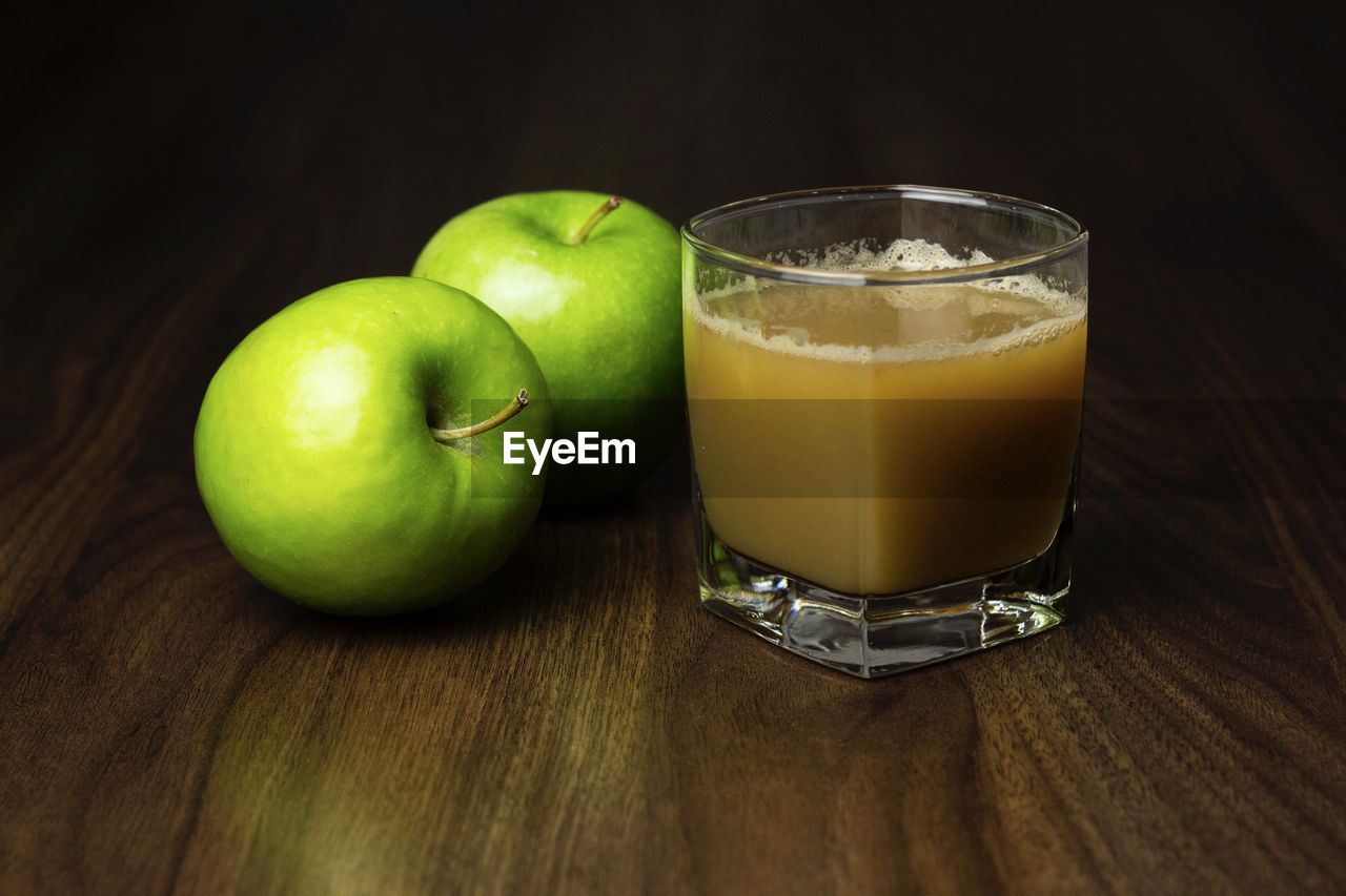 CLOSE-UP OF FRESH GREEN APPLE ON TABLE