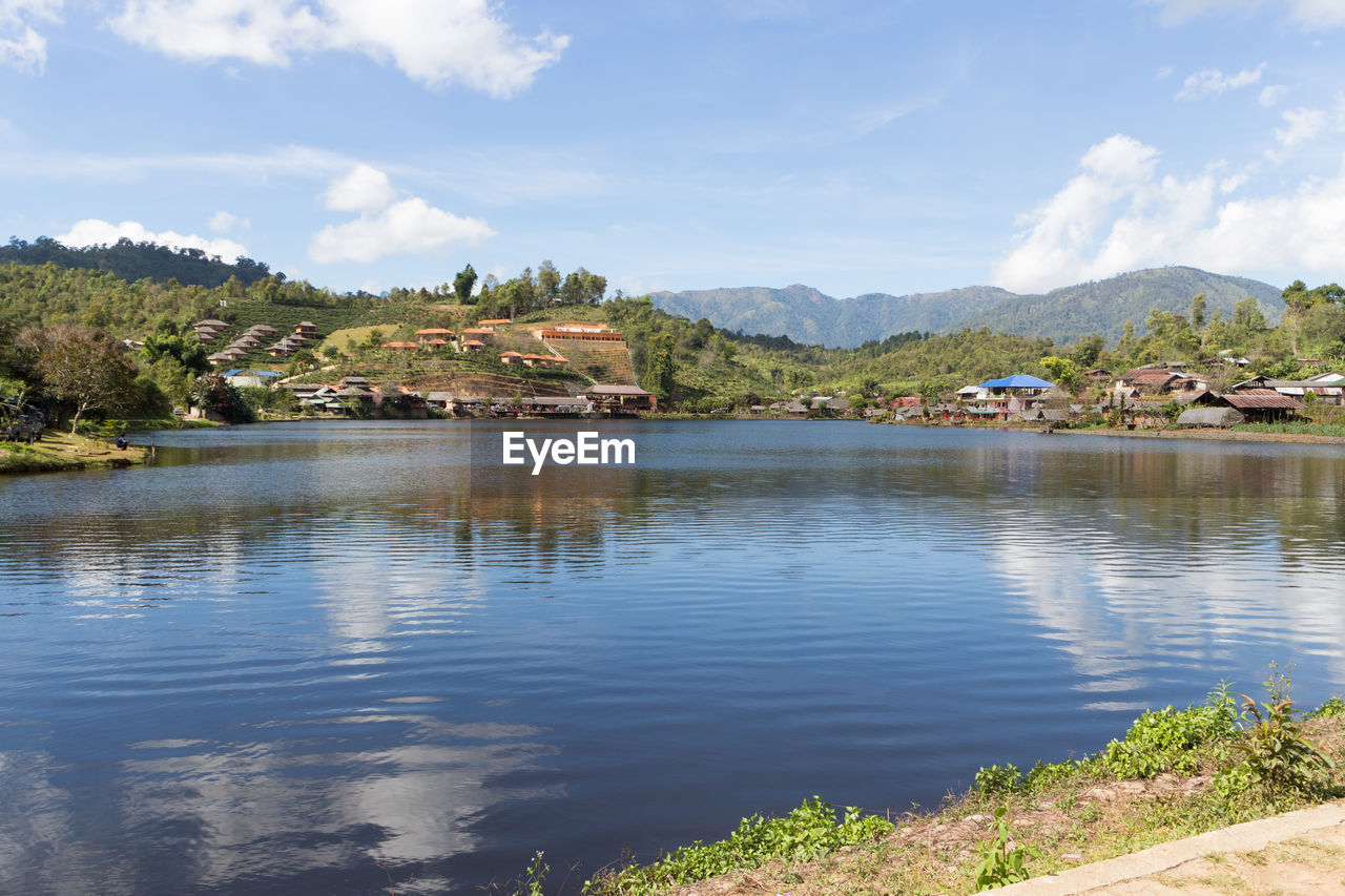 Scenic view of lake by buildings against sky