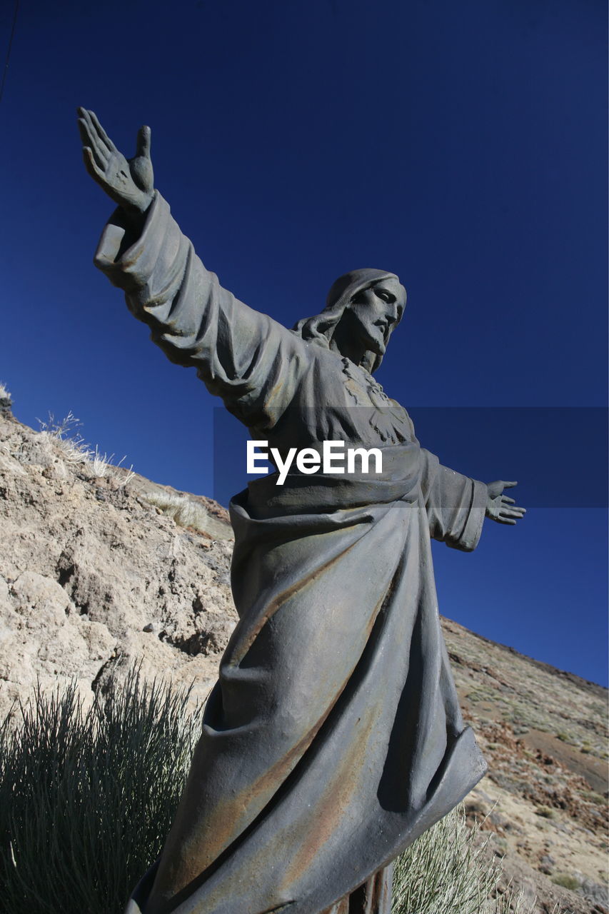 Low angle view of jesus christ statue against mountain