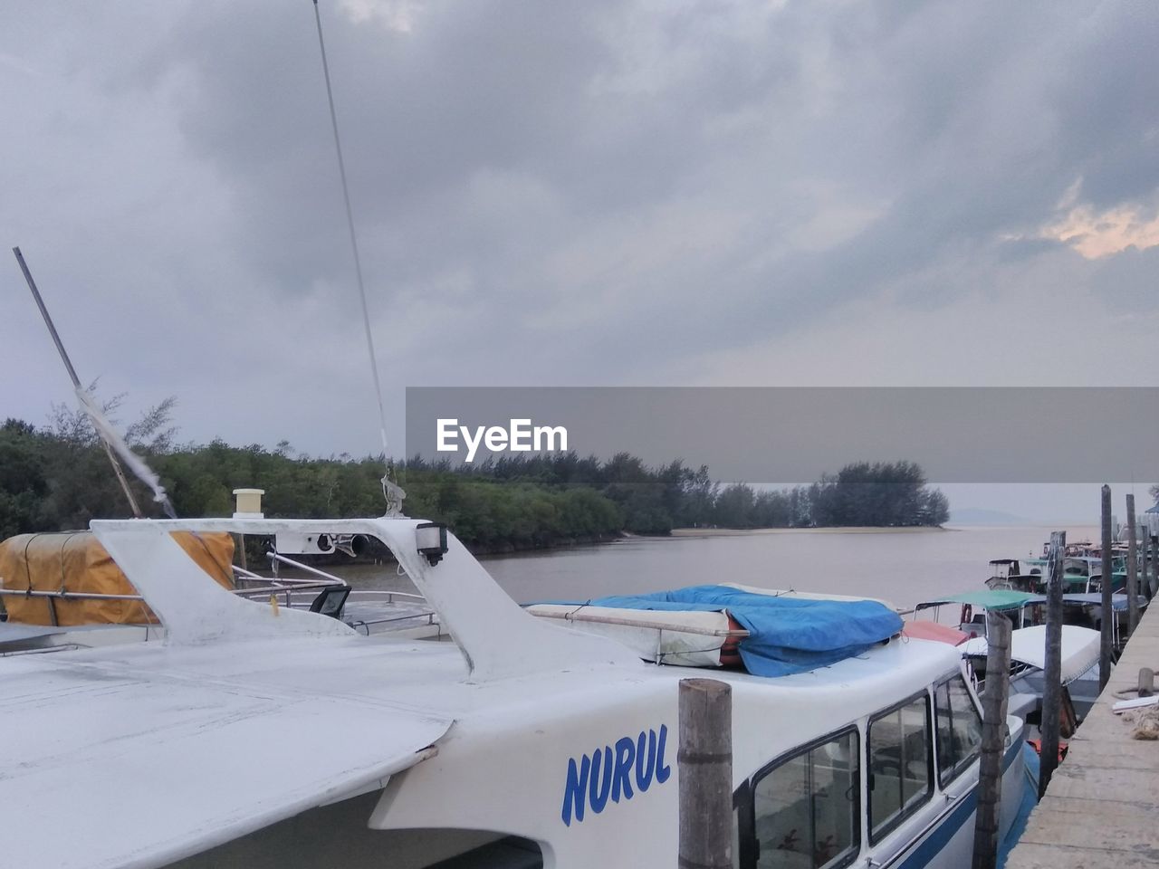 BOATS MOORED AT SEA AGAINST SKY